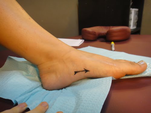 Very Tiny Black Arrow Tattoo On Foot