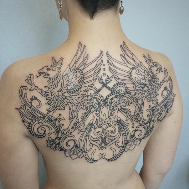 Amazing Mirror Griffin Tattoo On Upper Back Of Women