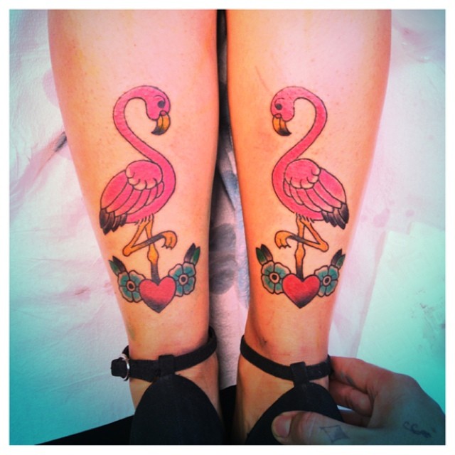 Flamingo Standing On Red Heart And Flower Tattoo On Both Legs.