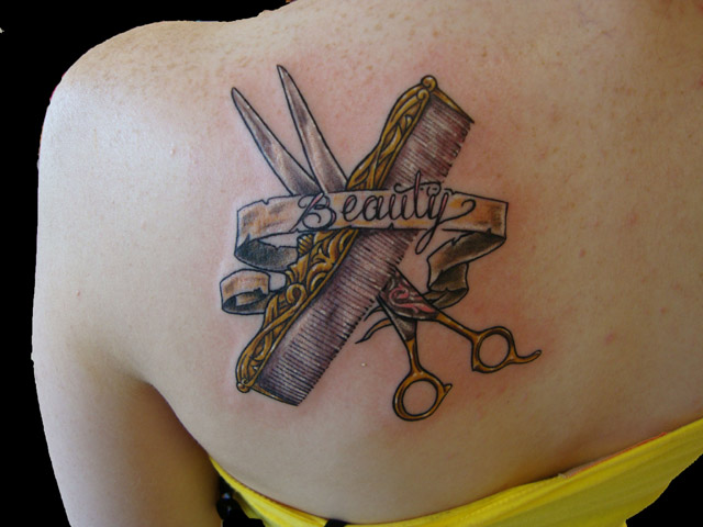 Gorgeous Comb And Scissor With Beauty Banner Tattoo On Left Shoulder