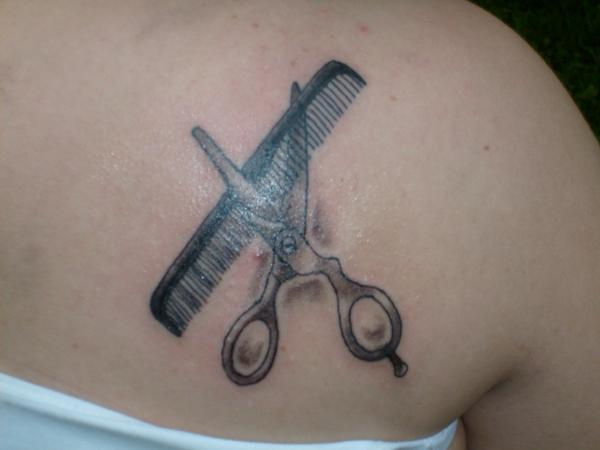 Grey Ink Hair Comb And Scissor Tattoo On Right Side Of Back