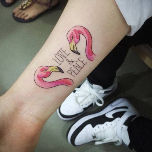 Two Flamingo Heads With Love And Peace Tattoo On Forearm