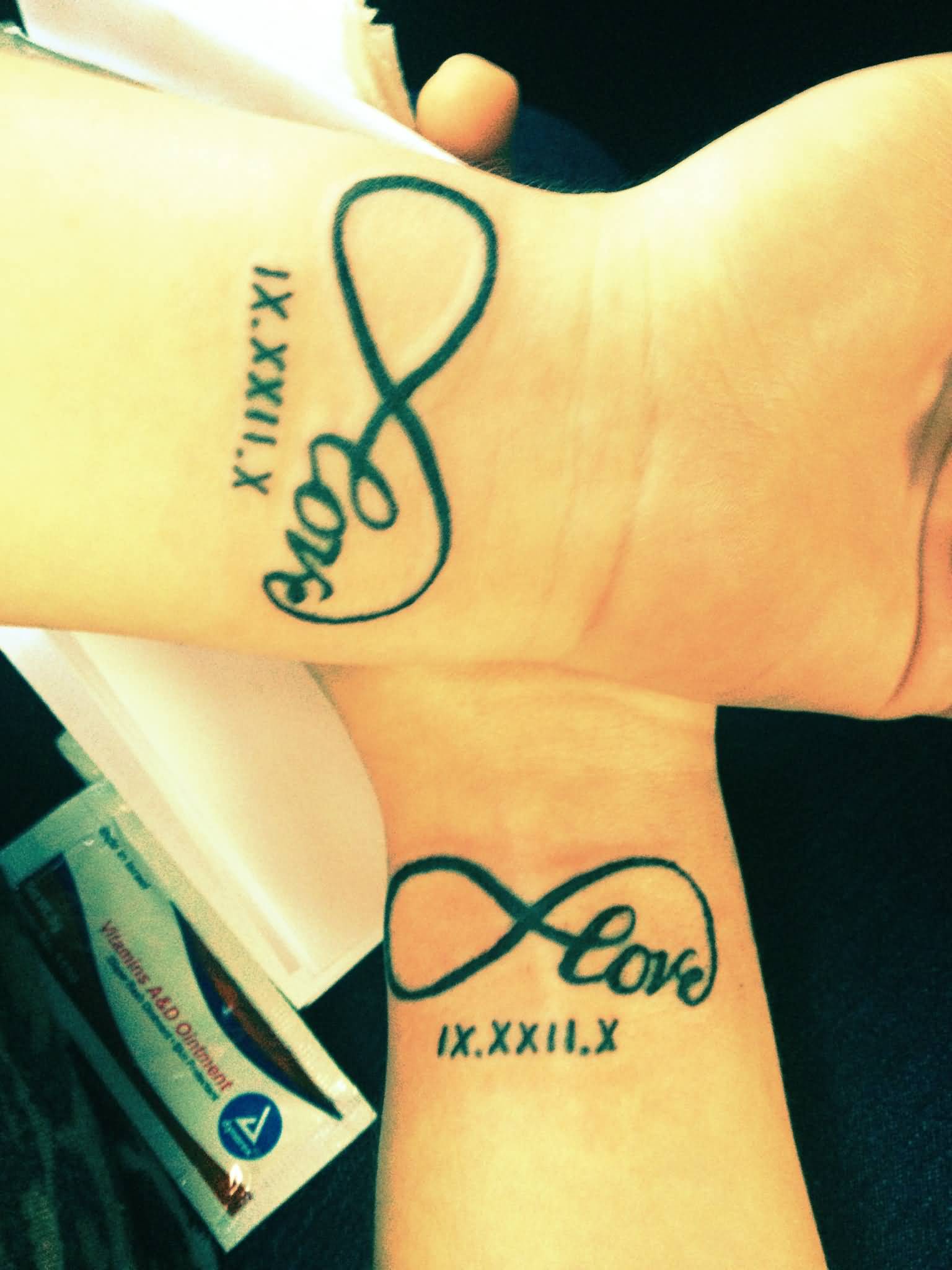 Beautiful Couple Roman Numerals Infinity Tattoo On Wrists