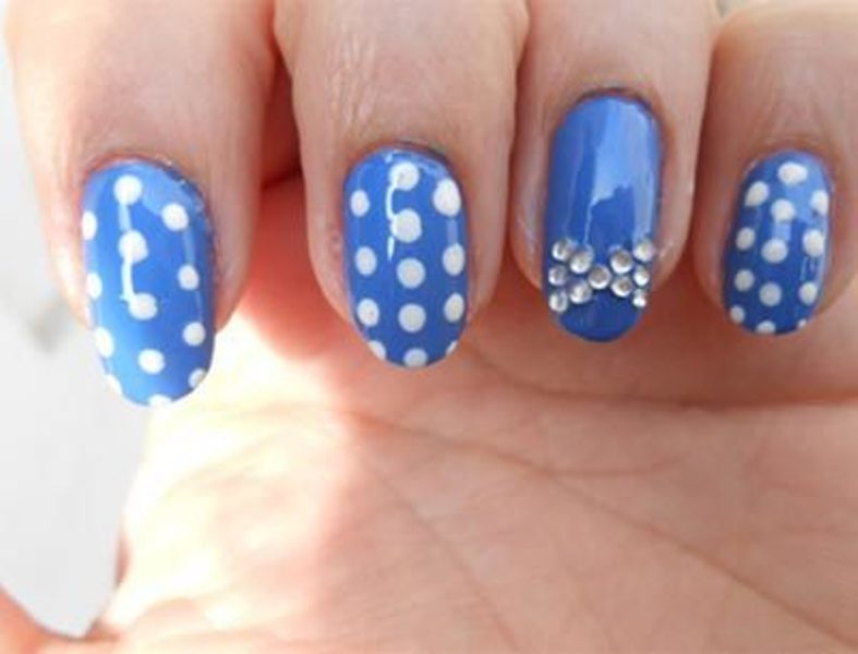 Blue Nails With White Polka Dots And Accent Rhinestones Bow Design