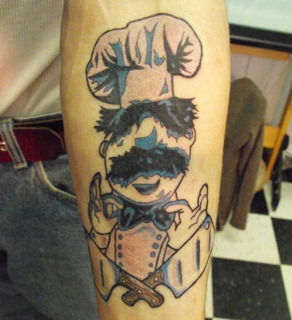 Chef Wearing Bow And Crossed Knife Tattoo On Forearm