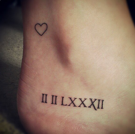 Fabulous Roman Numerals With Heart Shape Tattoo On Foot