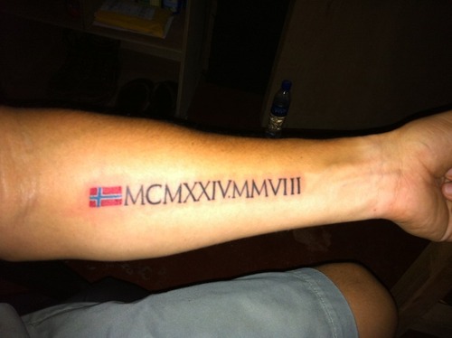 Flag With Roman Numerals Tattoo On Forearm