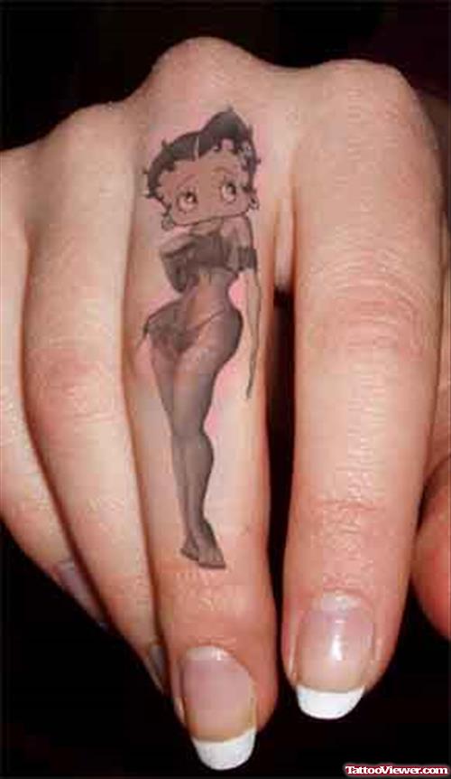 Grey Ink Betty Boop Tattoo On Middle Finger
