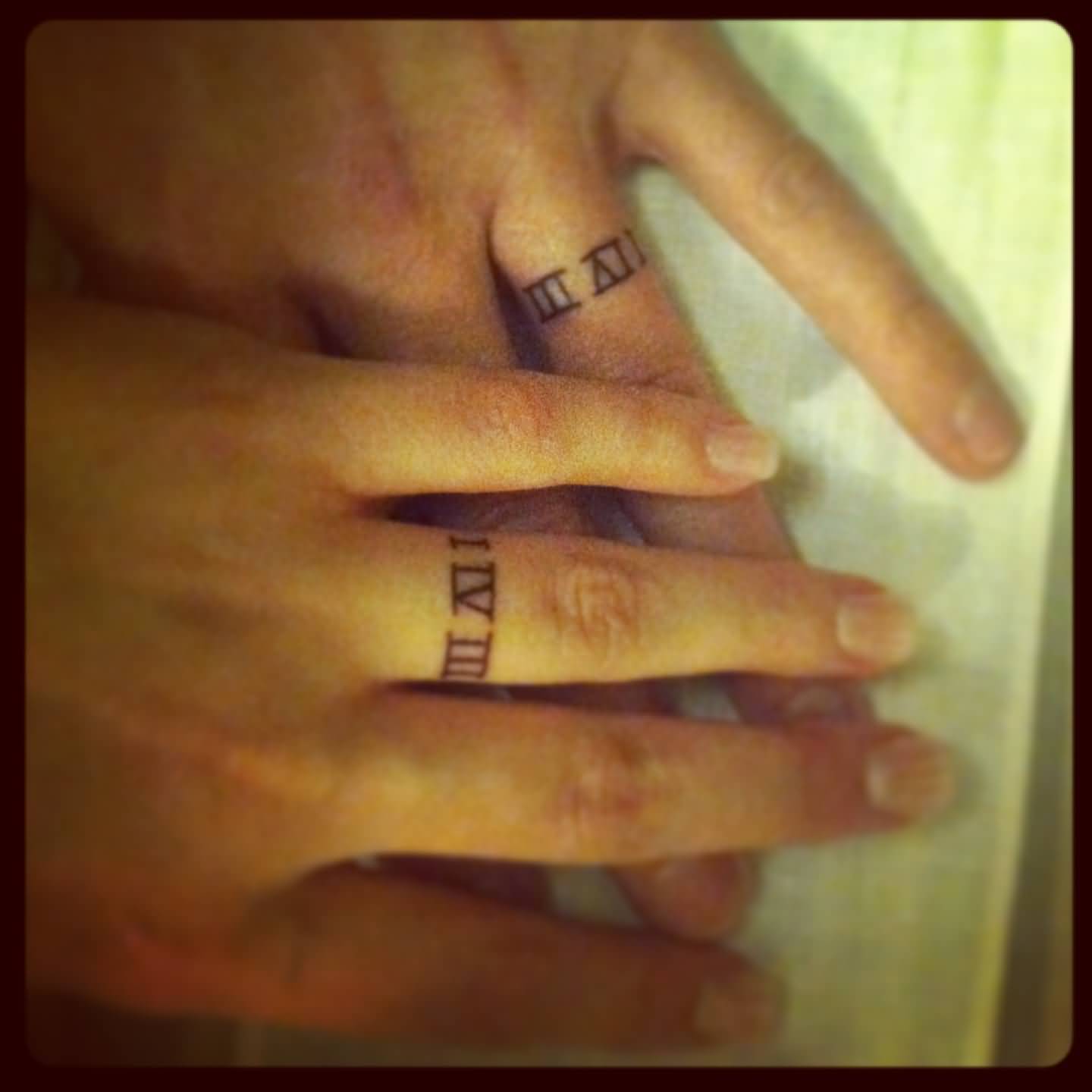 Matching Roman Numerals In Ring Shape Tattoos On Fingers