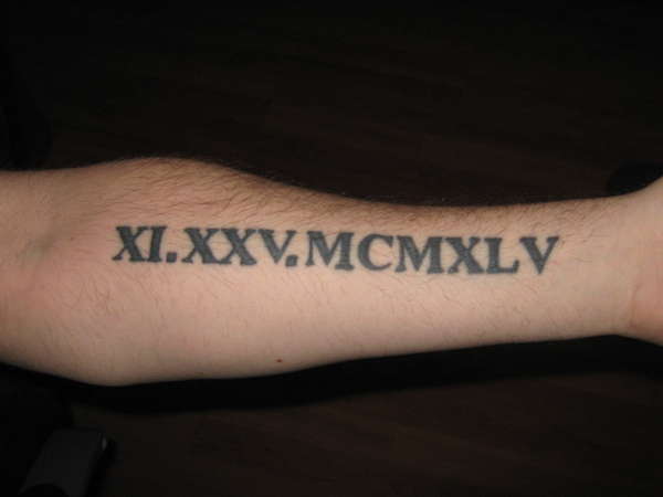 Nice Black Color Roman Numerals Tattoo On Forearm