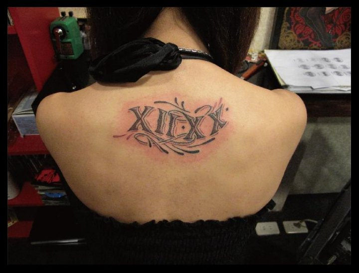 Nicely Designed Roman Numeral Tattoo On Upper Back