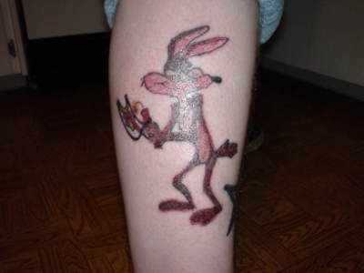Red Ink While E. Coyote Tattoo On Side Leg