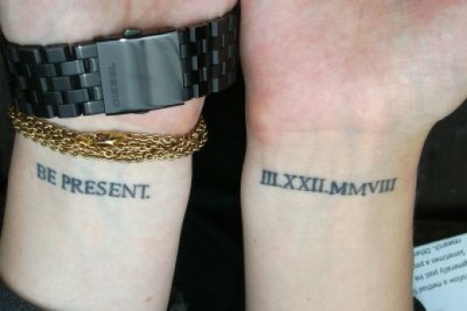 Roman Numerals With Be Present Tattoos On Wrists