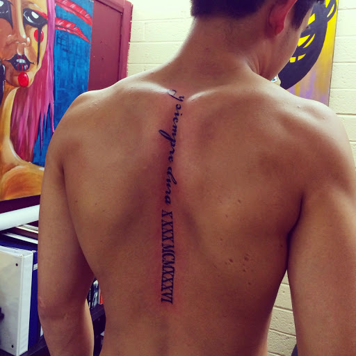 Roman Numerals With Lettering Tattoo On Spinal Cord