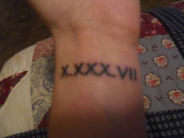 Simple Black Color Roman Numerals Tattoo On Wrist