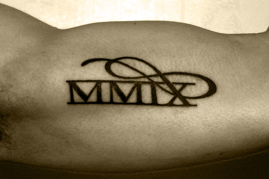 Small Roman Numeral Infinity Tattoo On Bicep