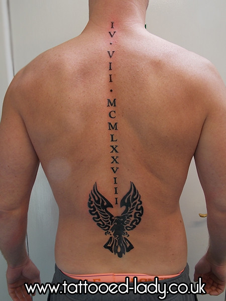 Tribal Eagle With Roman Numeral Tattoo On Spinal Cord