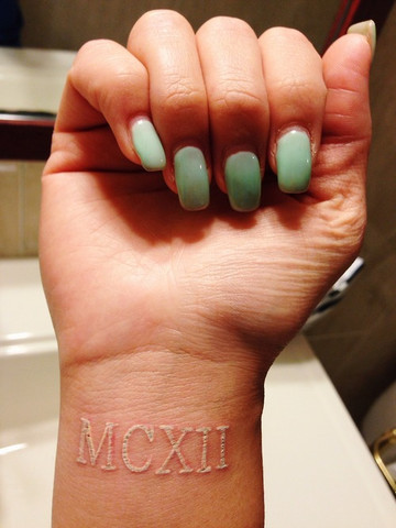 White Ink Roman Numerals Tattoo On Wrist For Girl