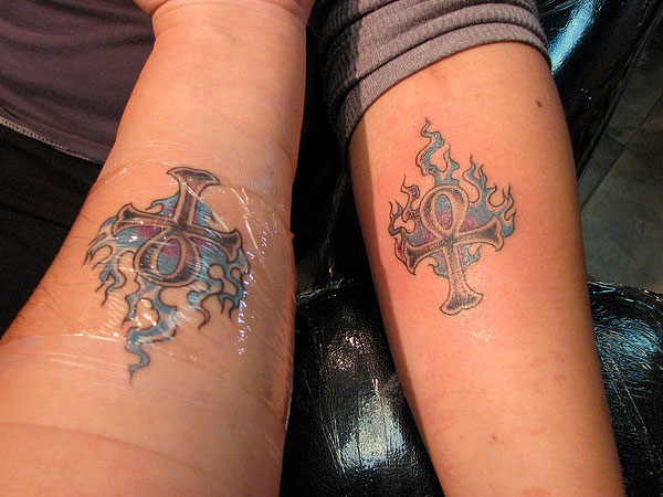 Blue Color Flames With Cross Matching Tattoos On Forearms