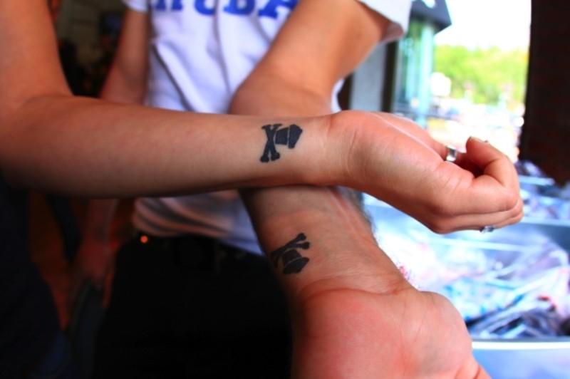 Cup Cake With Crossed Bones Silhouette Matching Tattoos On Wrists