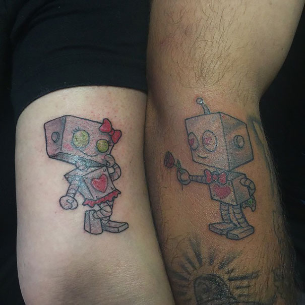 Cute Male Robot Giving Rose To Female Robot Matching Tattoos On Arm Sleeves