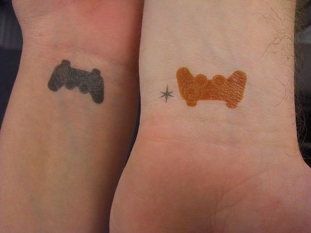 Different Colored Small Video Games Controller Tattoos On Wrists