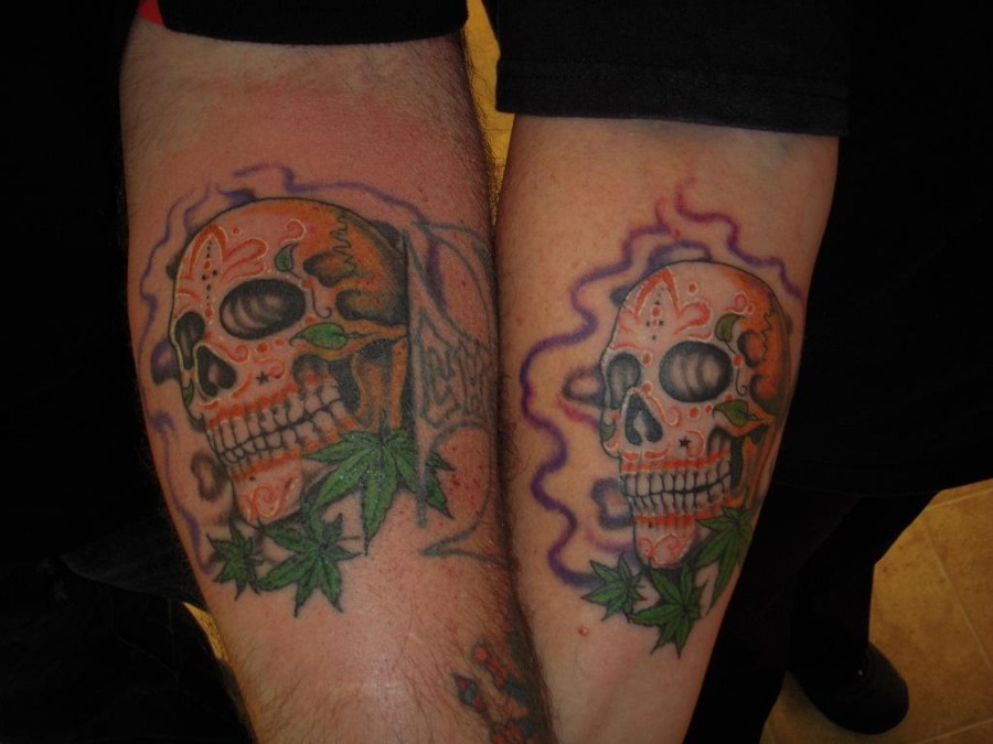 Flames With Sugar Skull And Leaves Matching Tattoos On Forearms
