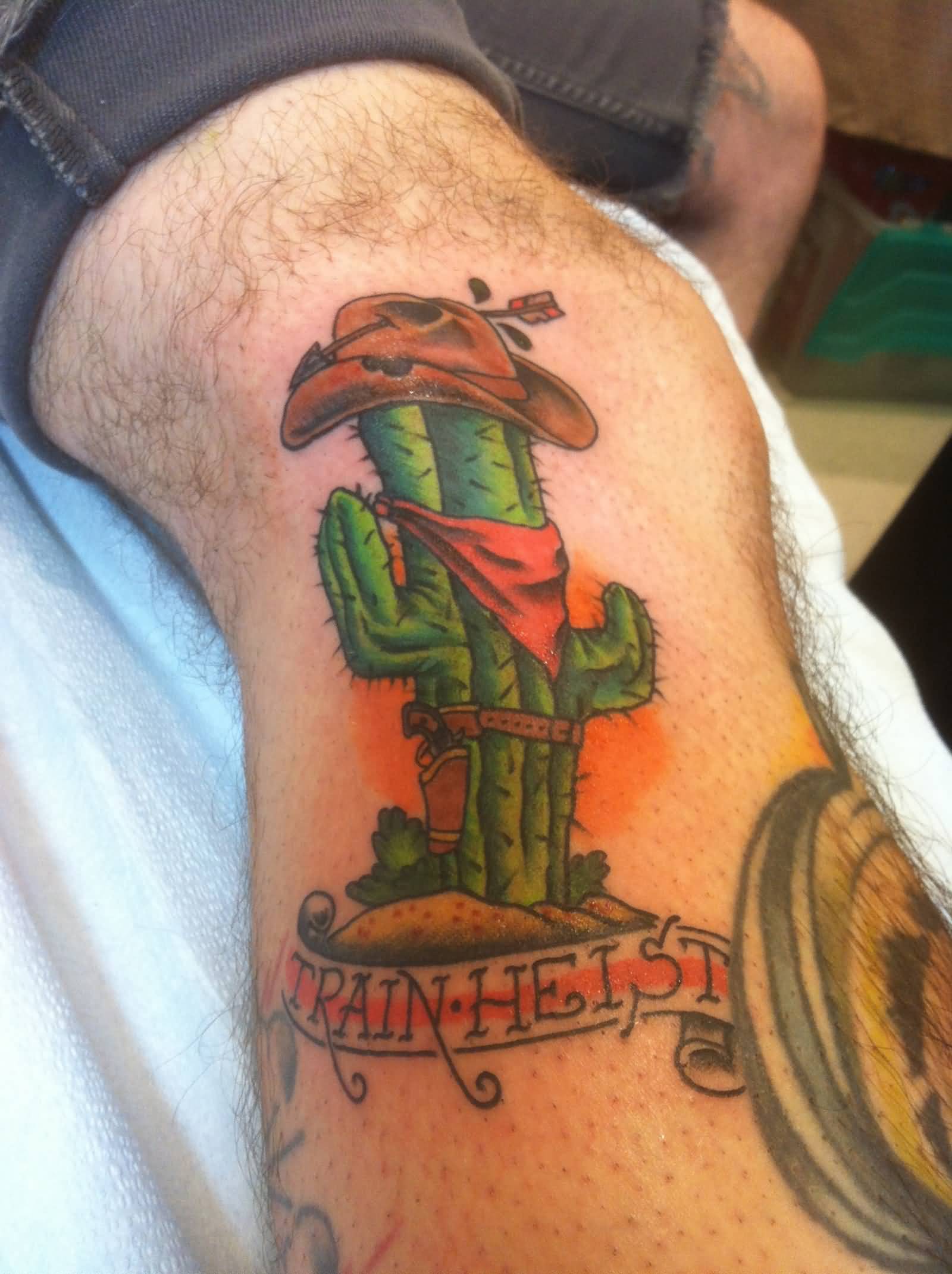 Funny Cowboy Cactus With Train Heist On Banner Tattoo On Leg