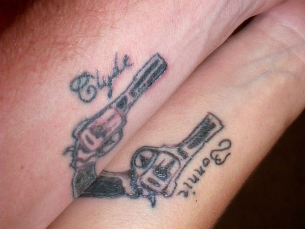 Gun With Name Matching Tattoos On Forearms