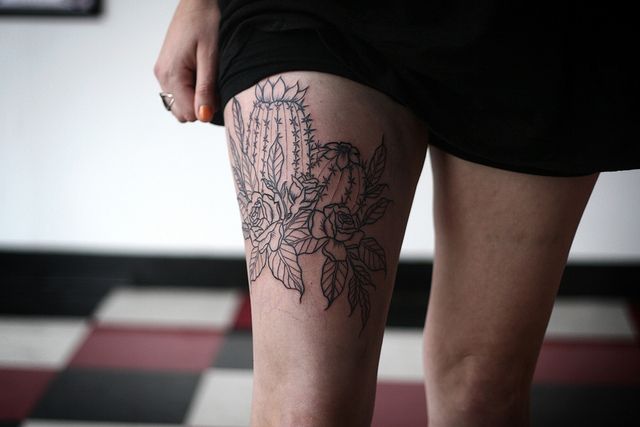 Nice Cactus With Flowers Design Tattoo On Thigh
