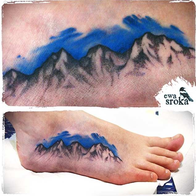 Nice Mountains With Blue Color Sky Tattoo On Foot