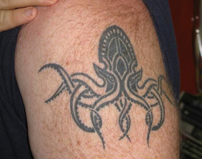 Outline Tribal Cthulhu Tattoo On Left Bicep