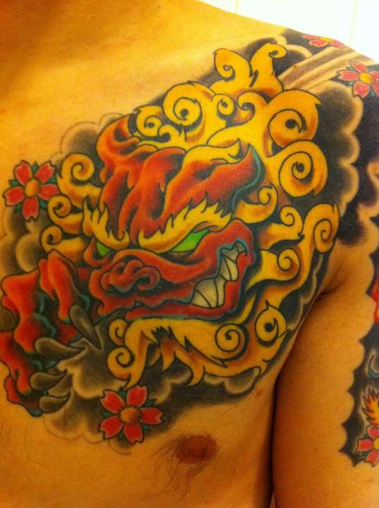 Red And White Chinese Foo Dog With Flowers Tattoo On Chest To Shoulder