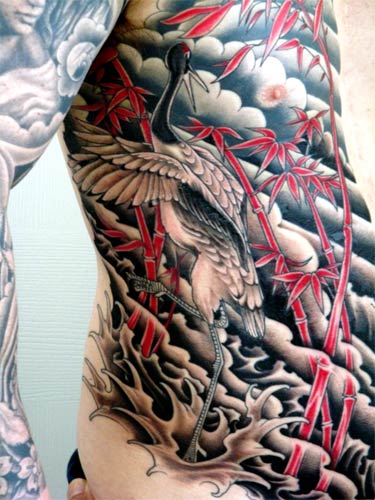 Red Bamboos And Flying Crane Tattoo On Side Rib