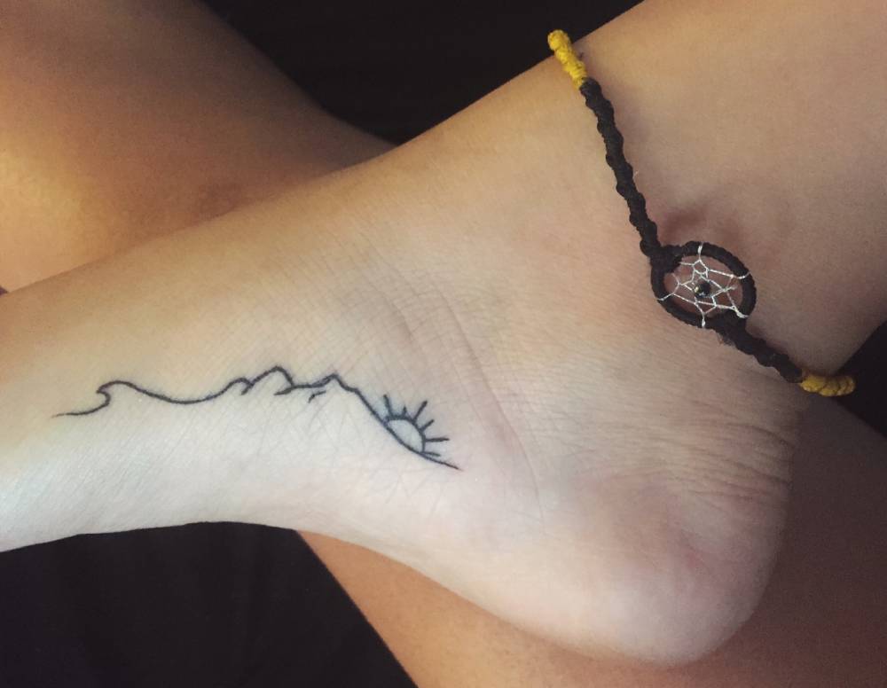 Simple Mountains With Rising Sun Tattoo On Foot