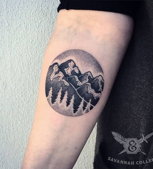 Small Dotwork Mountains And Trees In Circle Tattoo On Forearm
