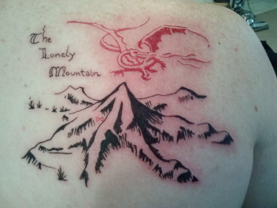 The Lonely Mountain With Lettering Tattoo On Upper Back