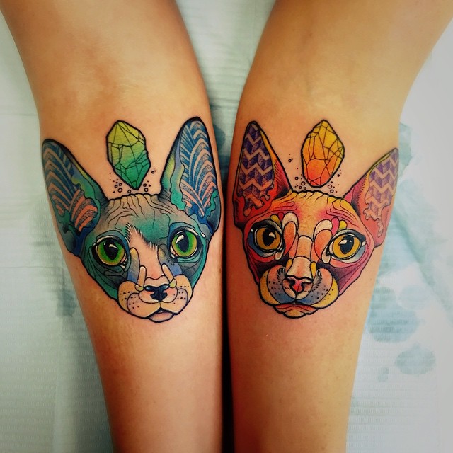 Two Colorful Sphynx Cats Head Matching Tattoos On Forearm