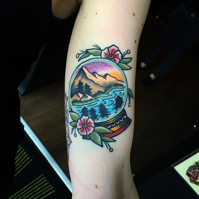 Wonderful Mountains In Globe Traditional Tattoo On Forearm