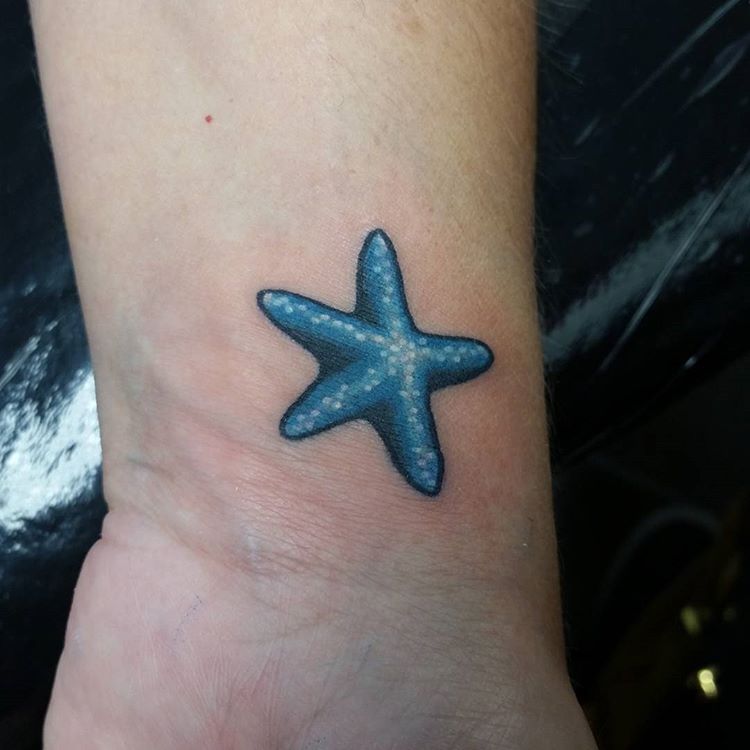 Minimalist starfish tattoo on the bicep.