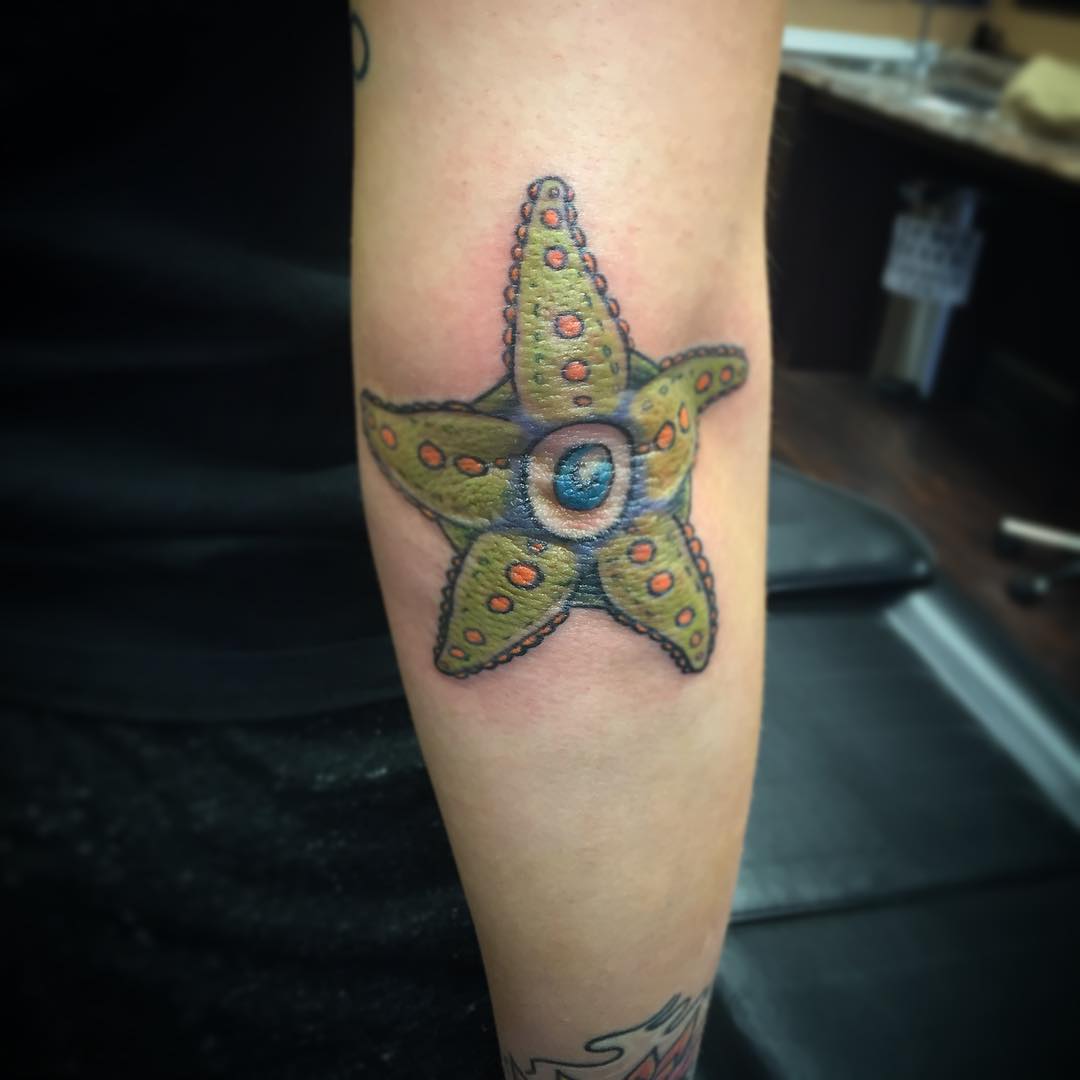 Colored Starfish Tattoo On Right Elbow.