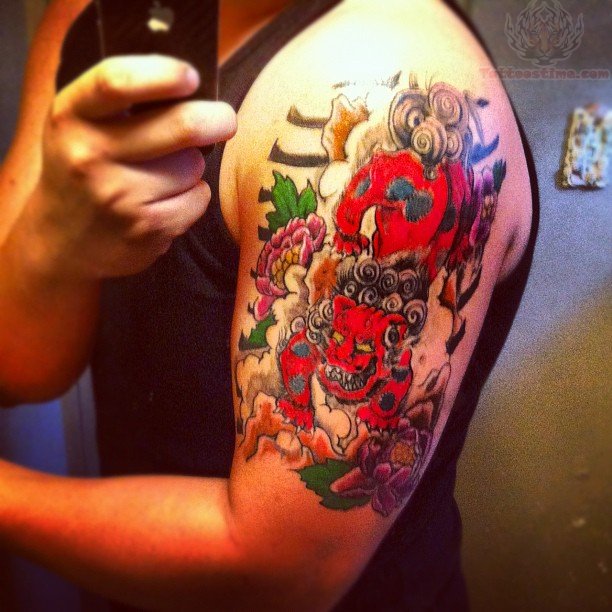 Colorful Angry Foo Dog With Leaves Tattoo On Left Shoulder
