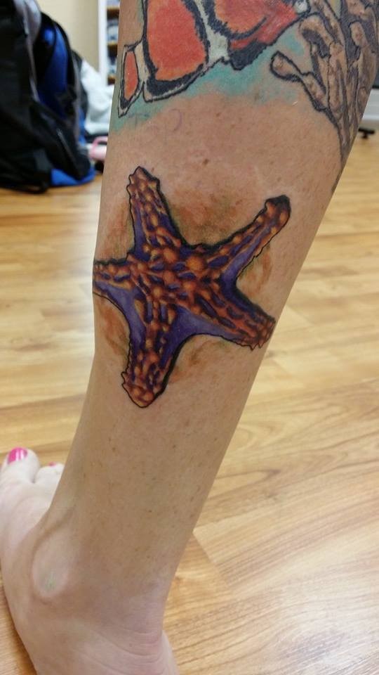 Colorful Starfish Tattoo On Back Leg