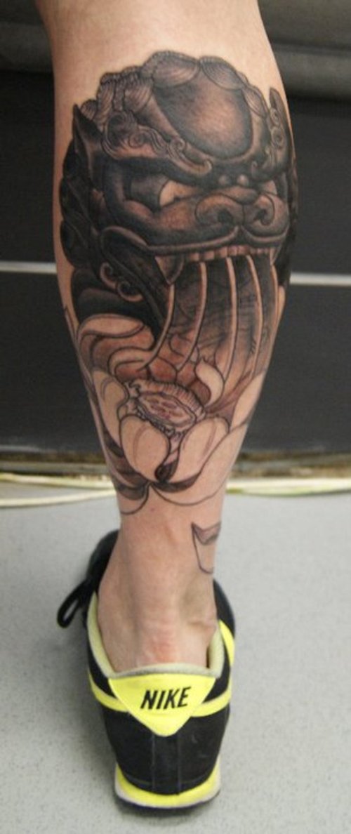 Dark Grey Ink Foo Dog Head With Flowers Tattoo On Back Leg