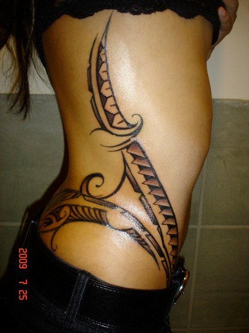 Glowing Tribal Design Tattoo On Side Rib To Hip For Girl