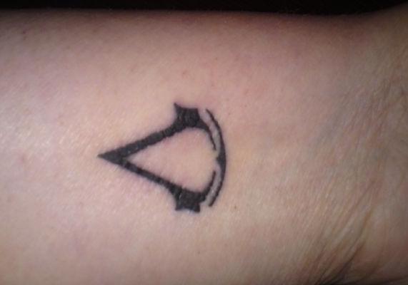 Grey Ink Assassins Creed Tattoo On Wrist
