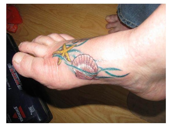 Nice Seashell With Starfish And Blue Water Lines Tattoo On Foot