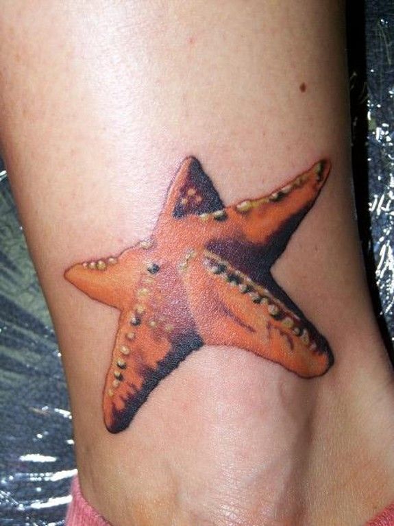 Realistic Orange Starfish Tattoo On Ankle