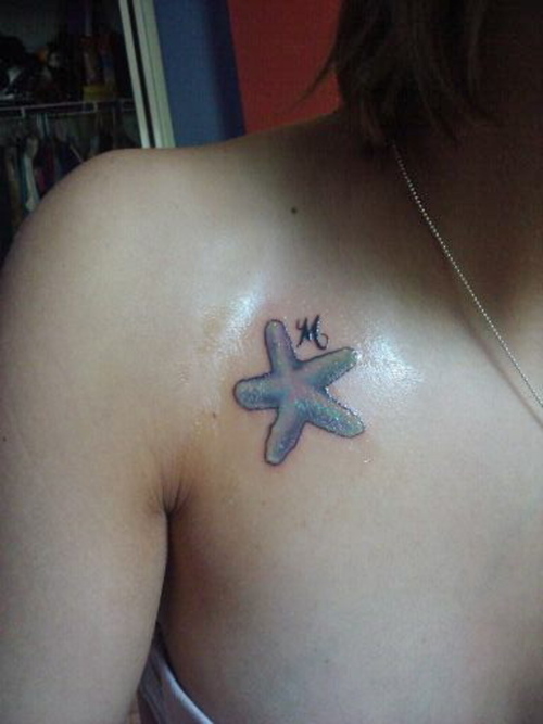 Small Blue Color Starfish With Letter M Tattoo On Collar Bone