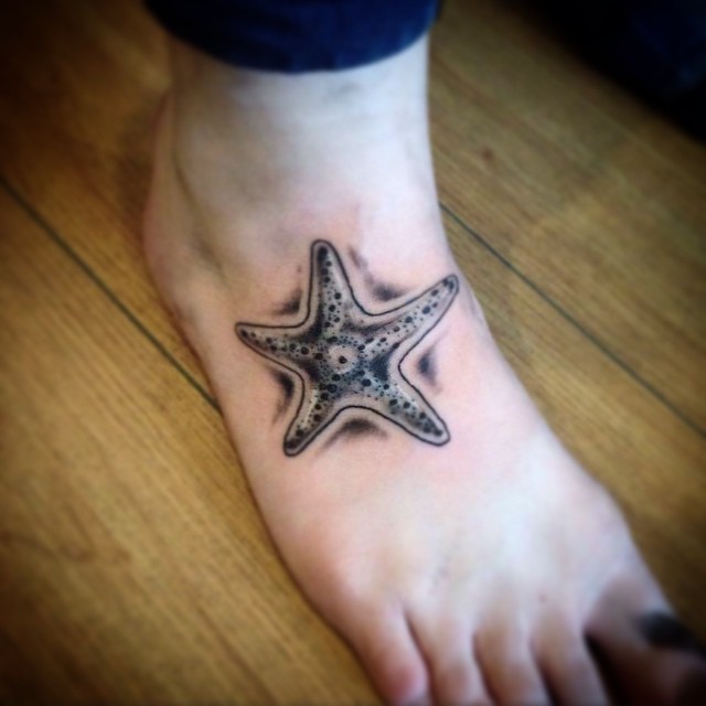 Unusual Black And White Starfish Tattoo On Foot